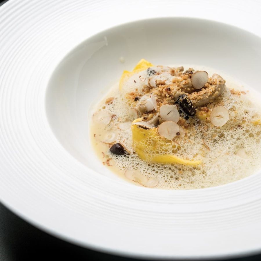 Balanzoni de Parmigiano Reggiano, caldo de gallina e hígado graso, crumble de avellanas y hongos de miel