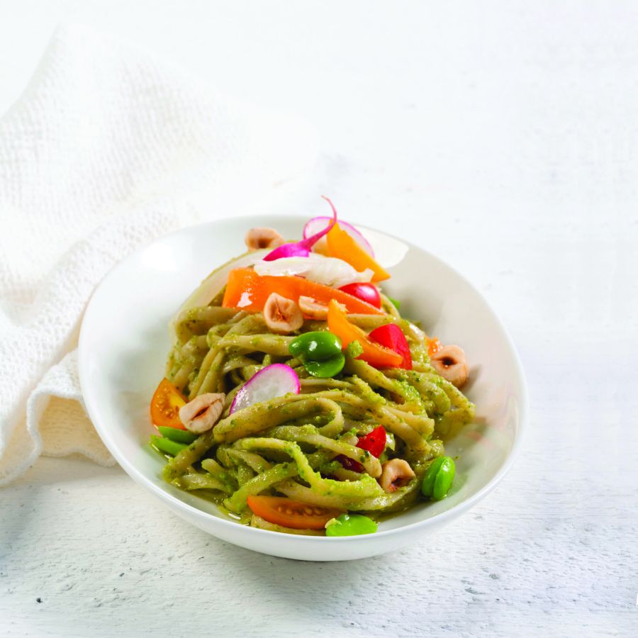 Linguine de verdura, guisantes y lentejas en ensalada fresca del huerto con pesto de habas y avellanas tostadas