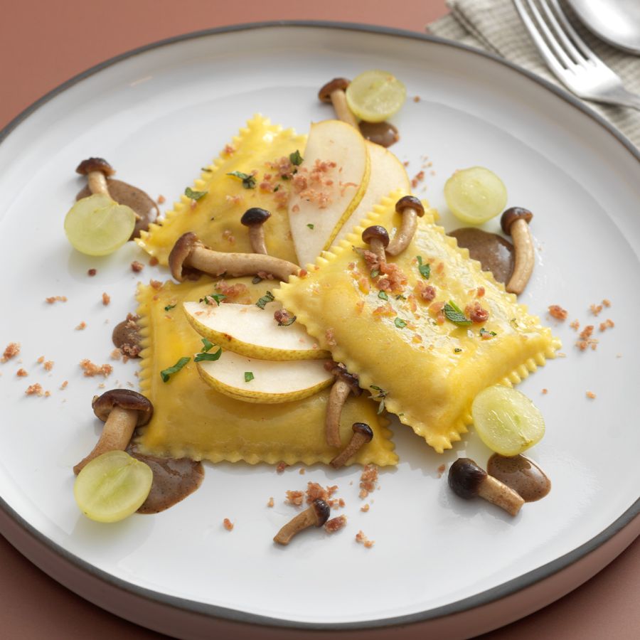 Ravioloni con formaggio Asiago DOP e Radicchio Rosso di Treviso IGP su crema di nocciola e caffè, funghi, pere e uva