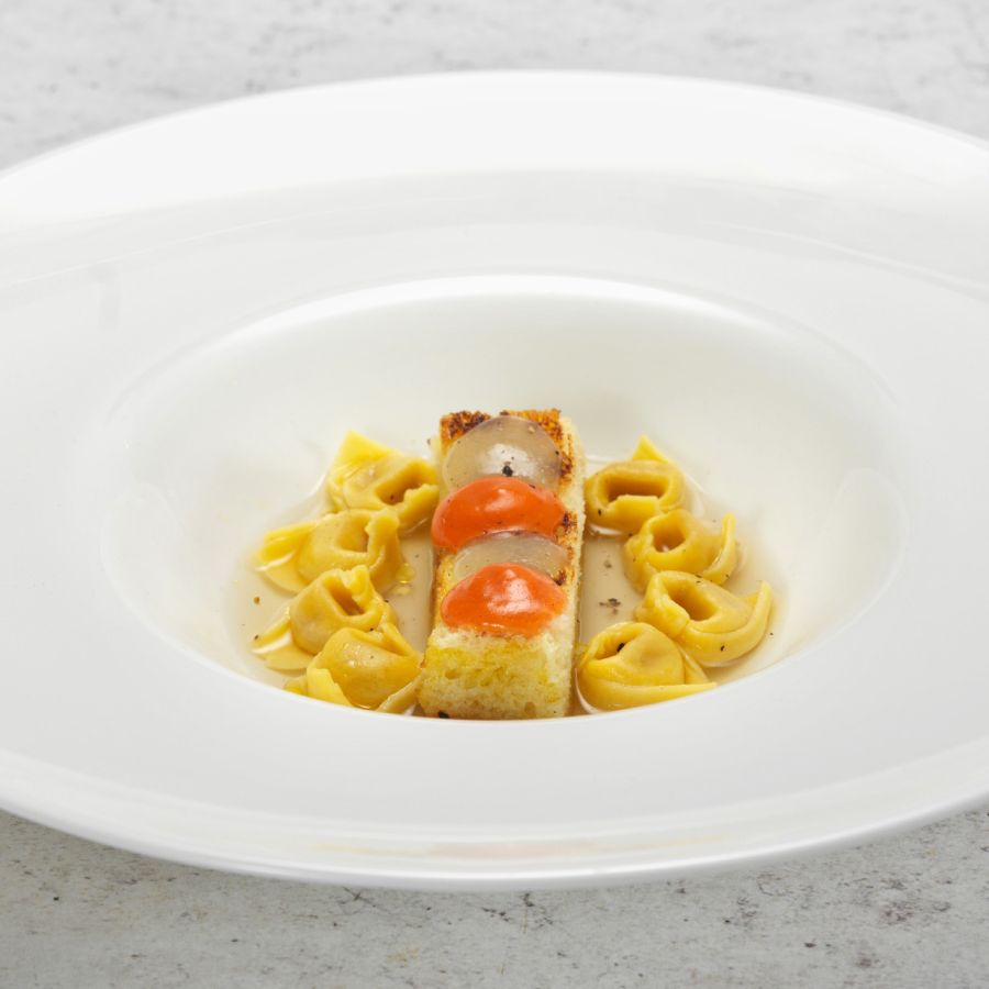 Tortellini nach Bologneser Art mit Parmesan-Brühe, gebranntem Lauch und Brotkruste mit Sellerie-Gel und Tomaten