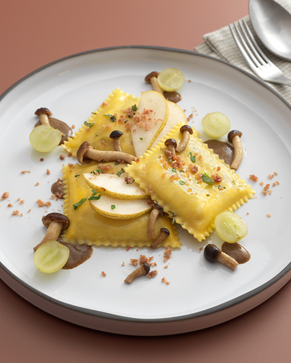 K111_Ravioloni-con-formaggio-Asiago-DOP-e-Radicchio-Rosso-di-Treviso-IGP_su-crema-di-nocciola-e-caffe-funghi-pere-e-uva