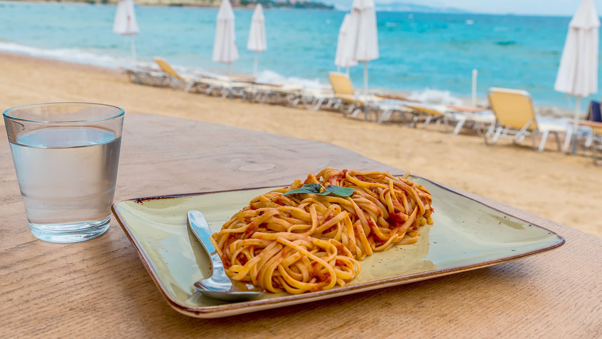 Un piatto di pasta su un tavolo con vista mare